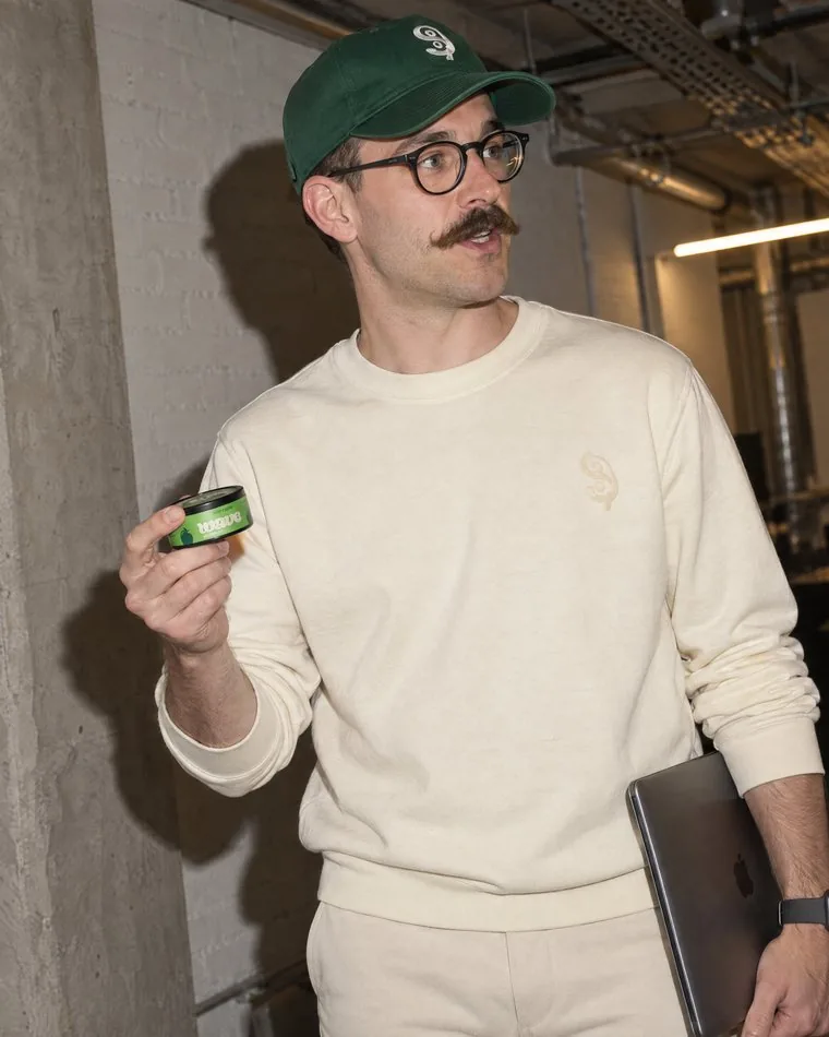 A man carrying a WAVE can through an office.